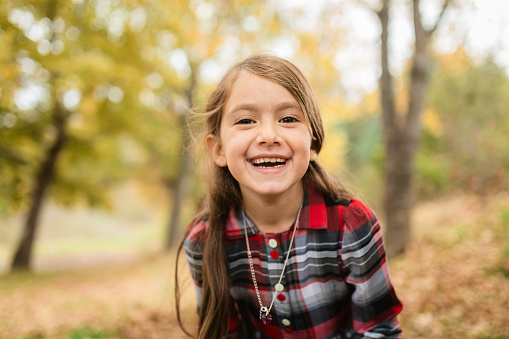 Portrait of Smiling girl looking at camera in autumn forest