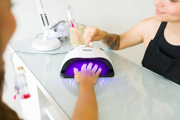 istock Latin woman using uv lighting after a manicure 1674527448