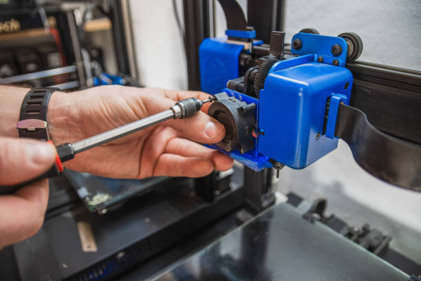 Close-up of technician's hands doing maintenance on 3D printer. Close-up of technician's hands doing maintenance on 3D printer. 3d printing hand stock pictures, royalty-free photos & images