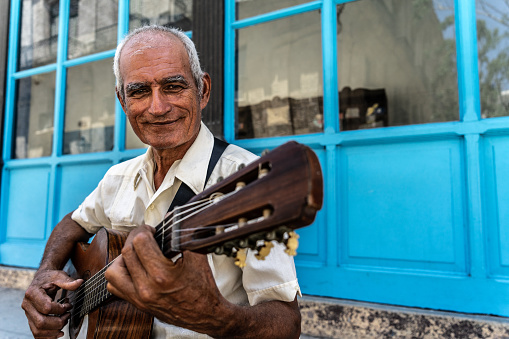 Portrait of a senior man playing the guitar outdoors