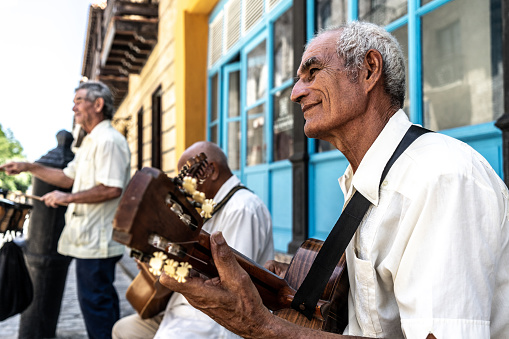 Senior man playing the guitar outdoors