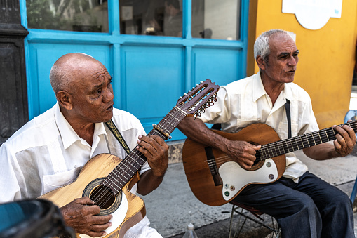 Senior men playing guitar and singing at the outdoors