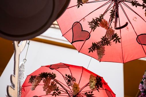 Red umbrellas backlit painted with hearts as a decoration object