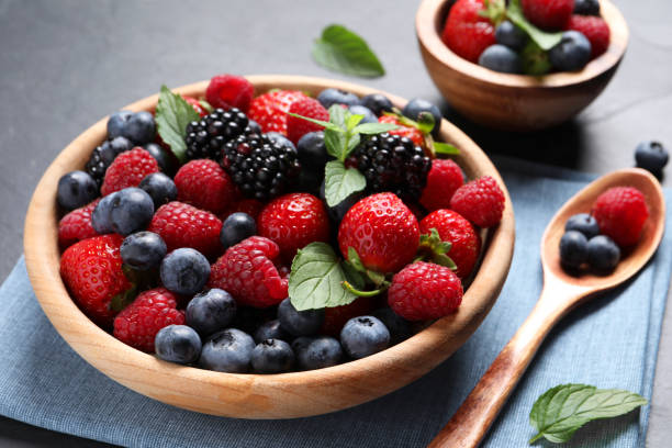istock Many different fresh ripe berries on black table, closeup 1674563760