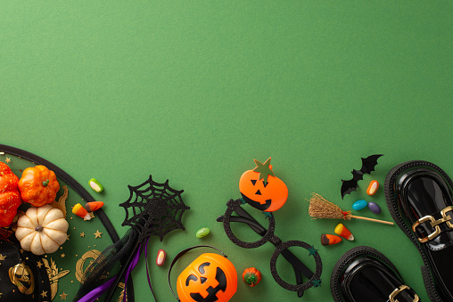 Indulge in Halloween ambiance with this enchanting overhead picture featuring witch attributes, Halloween-themed decorations on a green isolated background, ideal for text or advert placement