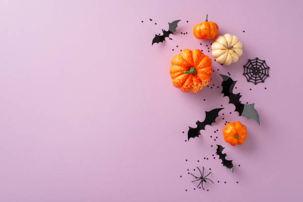 istock Shop eerie discounts: Top view shot displaying decorative pumpkins, spider, cobweb, bats and confetti on lilac context. Ad-friendly open area for content 1674567040