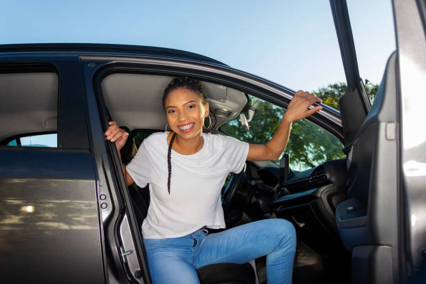 istock young woman posing with her new car 1674580651