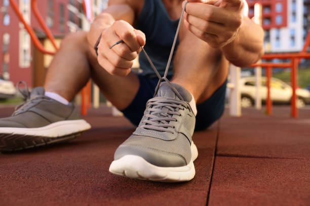 istock Man tying shoelaces before training at outdoor gym, closeup 1674590191
