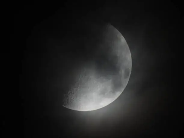 Clouds moving in.  Called the "first quarter" because the moon has traveled about a quarter of the way around the Earth since the new moon. The First Quater phase follows the Waxing Crescent.
