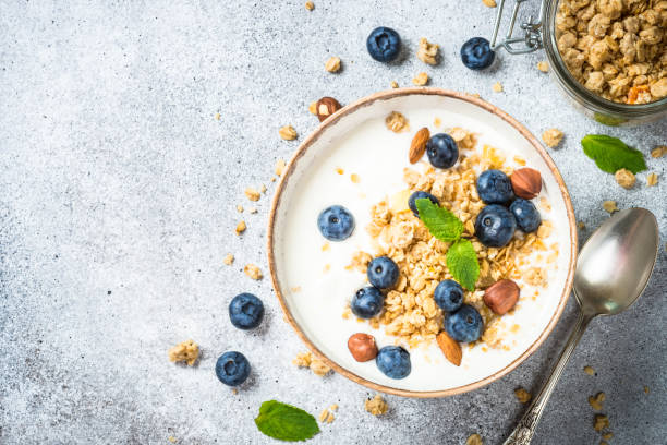 istock Yogurt granola with fresh blueberries on stone table. 1674593379