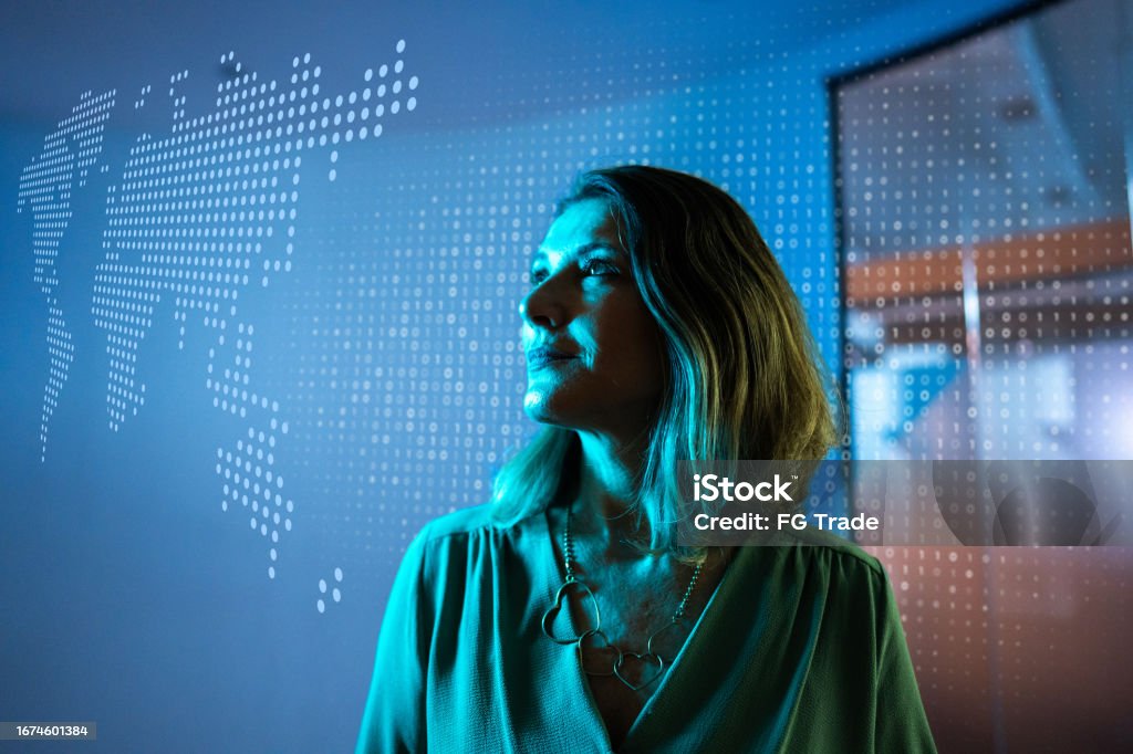 Mature businesswoman looking to a hologram at office - Royalty-free Tecnologia Foto de stock Mature businesswoman looking to a hologram at office - Royalty-free Tecnologia Foto de stock