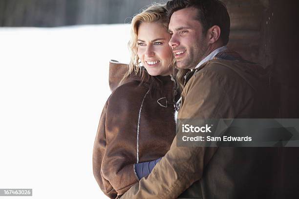 Photo libre de droit de Souriant Couple Embrassant Dans La Neige banque d'images et plus d'images libres de droit de Hiver - Hiver, 30-34 ans, S'enlacer