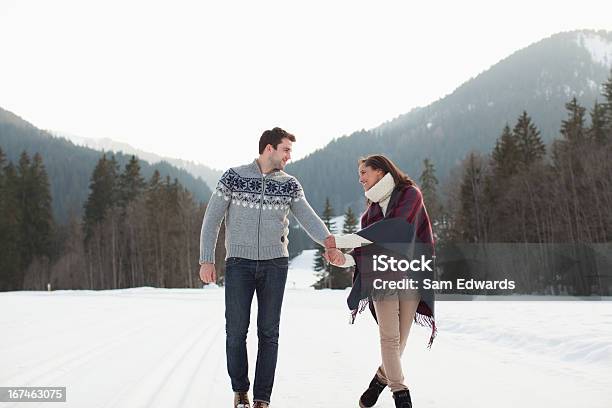 Sonriente Pareja Sosteniendo Las Manos Y Caminar En Campo Nival Foto de stock y más banco de imágenes de Aislado