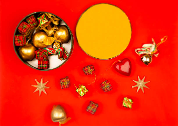 High angle view of Christmas metal container with objects to decorate the home for Christmas season over red background