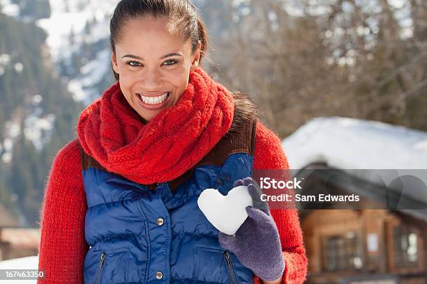 Photo libre de droit de Portrait De Femme Souriante Tenant Coeur En Forme De Boule De Neige banque d'images et plus d'images libres de droit de 30-34 ans