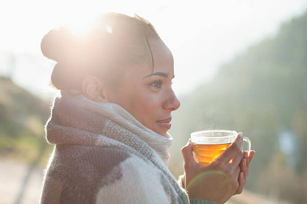 Close up of smiling woman drinking tea outdoors  tea hot drink stock pictures, royalty-free photos & images