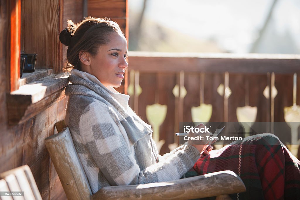 Улыбающаяся женщина с Бумага и ручка на коттедж Veranda - Стоковые фото 30-34 года роялти-фри