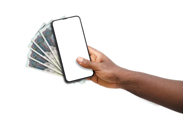 istock Black hand holding mobile phone with blank screen and Egyptian pound notes 1674657564