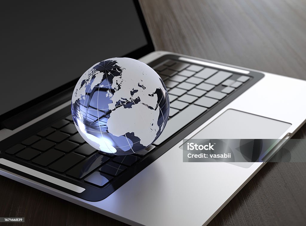Laptop 3D image of modern laptop and crystal globe on wooden desk Desk Stock Photo