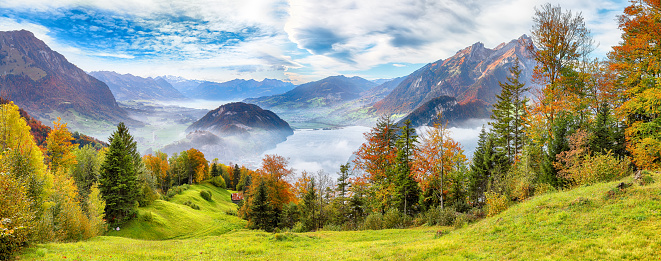 Outstanding  autumn view on suburb of Stansstad city  and Lucerne lake with mountaines and fog. Poppular travel destination in Swiss Alps.   Location: Stansstad, Canton of Nidwalden, Switzerland, Europe