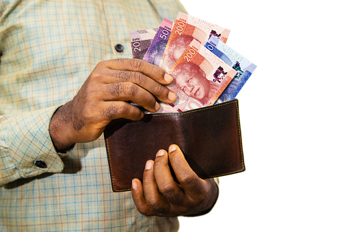 Black person Holding brown wallet
With South African Rand notes, hand removing money out of wallet over white background removing money from wallet