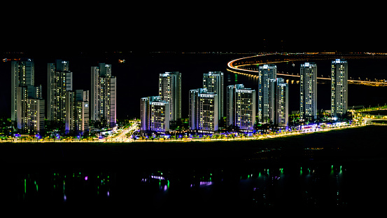 Incheon City South Korea Cityscape on a summer night with a view of the curving Incheon Bridge linking Yeongjong Island with the mainland, built in multi-sections to withstand earthquakes