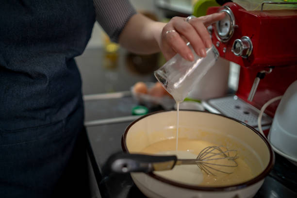 istock woman pouring milk into dough at kitchen 1674773394