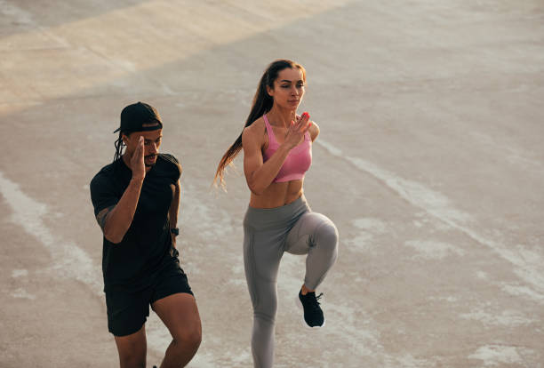 istock High angle of two athletes jumping together doing warming up before a run 1674792865