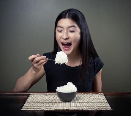 Chinese girl eating a heaping pile of rice.