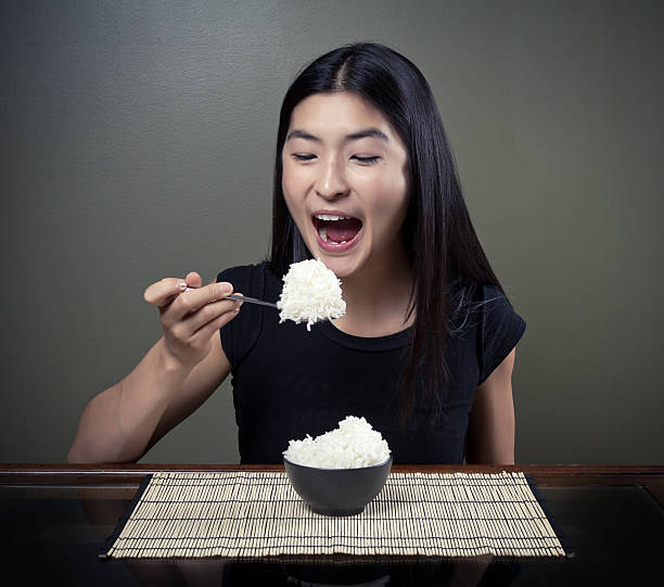 Chinese Girl Eating Lots Of Rice stock photo