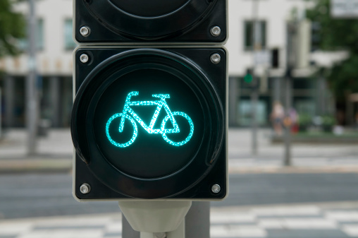 An illuminated blue bicycle traffic light signal in Copenhagen, indicating a bicycle path.