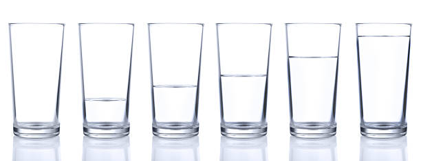 Six glasses with different levels of water stock photo