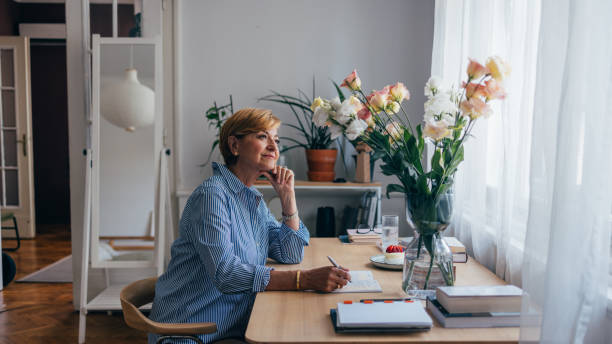 istock Beautiful Senior Woman Writing in Her Diary 1674853328