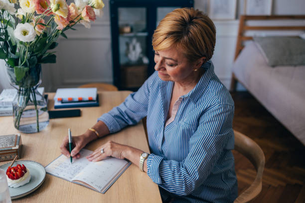 istock Serious Beautiful Senior Woman Writing in Her Diary 1674853331