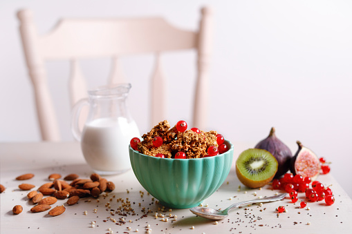 Gluten free crunchy granola in a bowl with fig, currant and kiwi