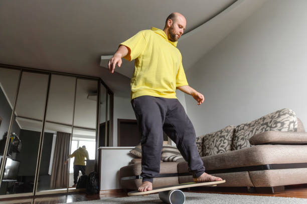 istock Man is standing on the balance board 1674875658