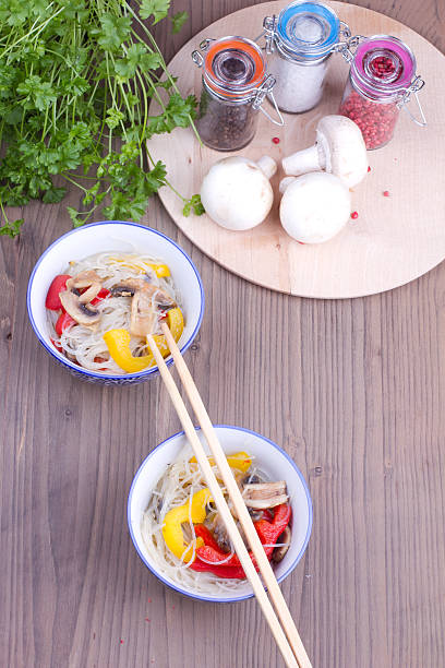 Two dishes of chinese vermicelle and chopsticks