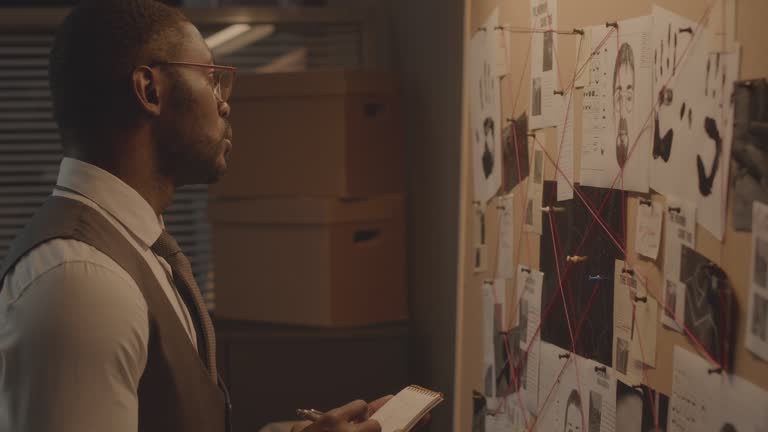 African American Detective Analyzing Evidence Board at Night Office