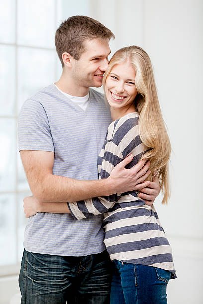 istock happy young caucasian couple hugging indoors 167490459