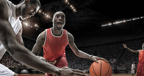 Extreme Close Up Basketball Action Close up view of professional basketball players during game in floodlit arena blocking sports activity stock pictures, royalty-free photos & images