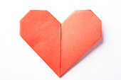 A red origami heart on a white background