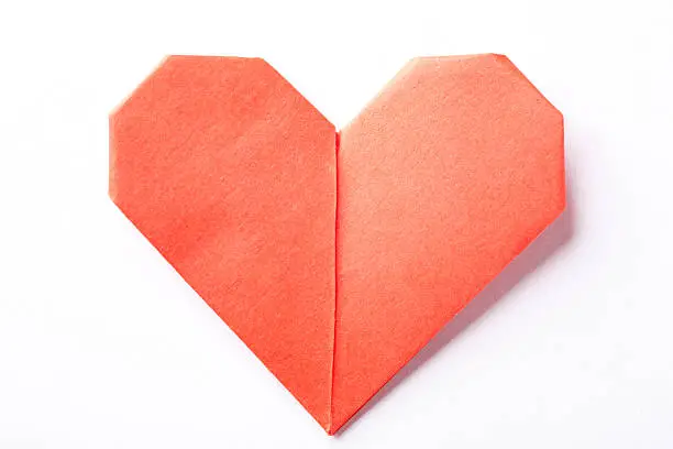 Photo of A red origami heart on a white background