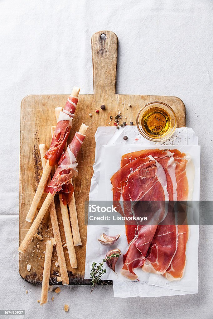 Bread sticks with ham Bread sticks with ham on wooden cutting Board Antipasto Stock Photo