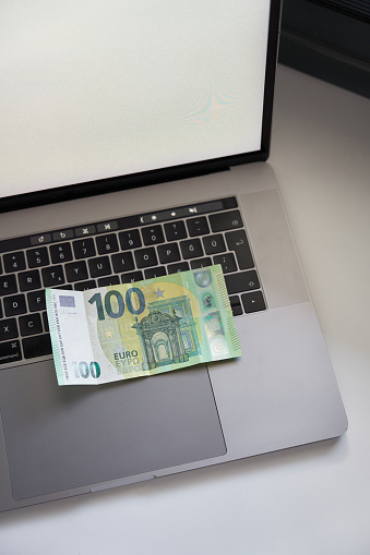 one hundred euro banknote and laptop