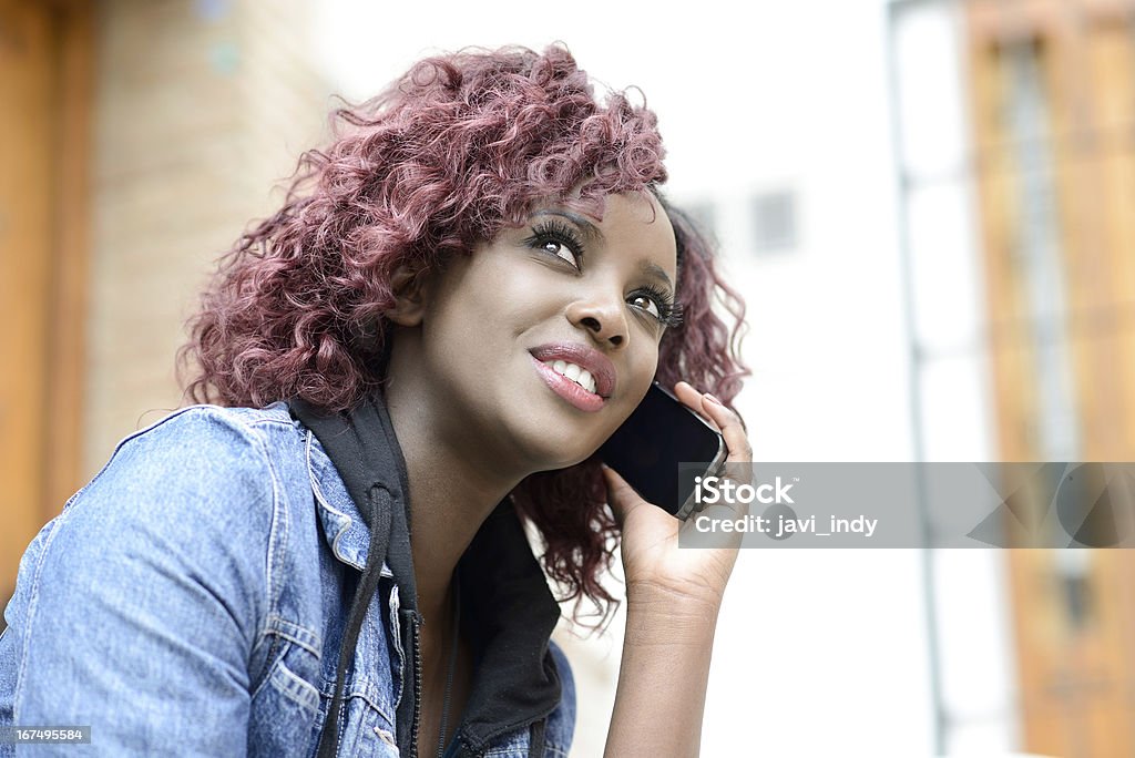 Hermosa mujer negra en fondo urbano en el teléfono - Foto de stock de 16-17 años libre de derechos