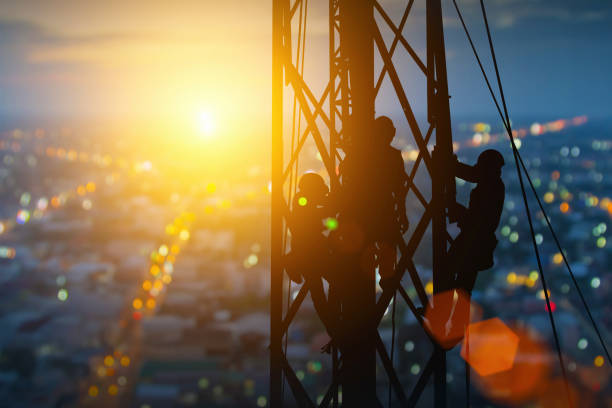 istock silhouette workers on background of construction crews to work on high ground heavy industry and safety concept. Construction of the extension of high-voltage towers on blurred nature background. 1674979543