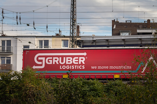 Picture of a sign with the logo of Gruber Logistics on a container being shipped by rail in Cologne, Germany. Gruber Logistics is a container shipping and logistics service company.