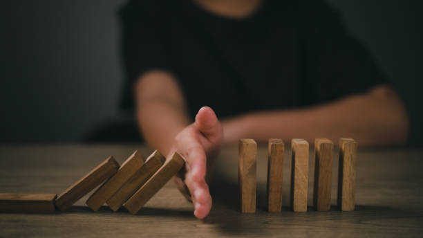 istock Hand-stopping domino effect. Concept of risk protection, business solution, or successful intervention strategy. 1675007188