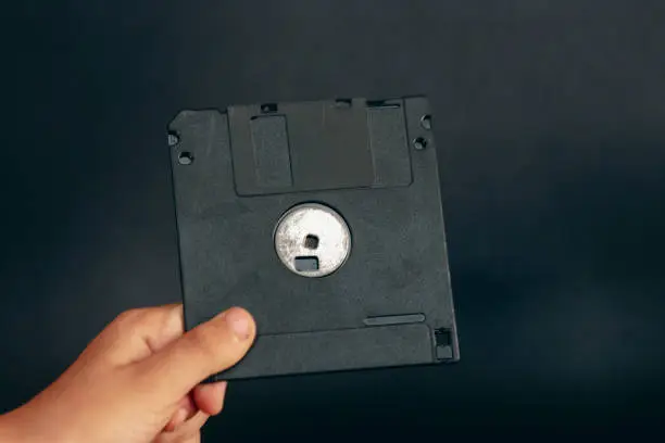 close up of a hand holing Floppy disk