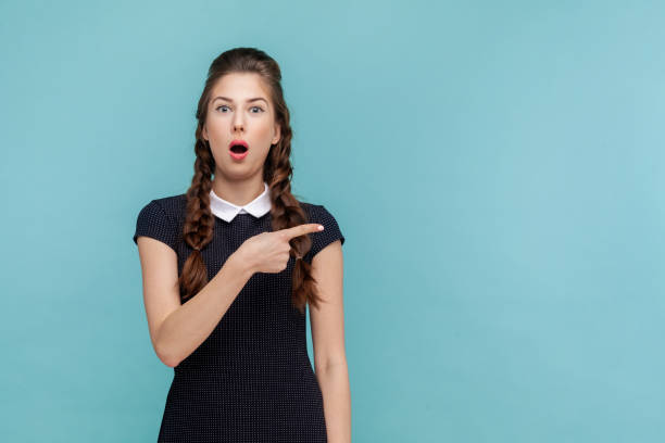 istock shocked surprised woman points away on copy space, suggests follow this direction or click on link. 1675138896